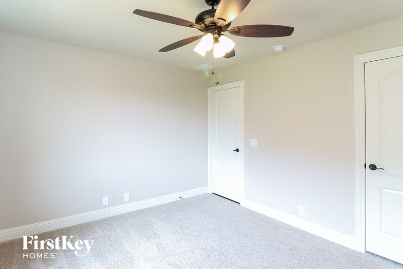 a bedroom with a ceiling fan and a closet