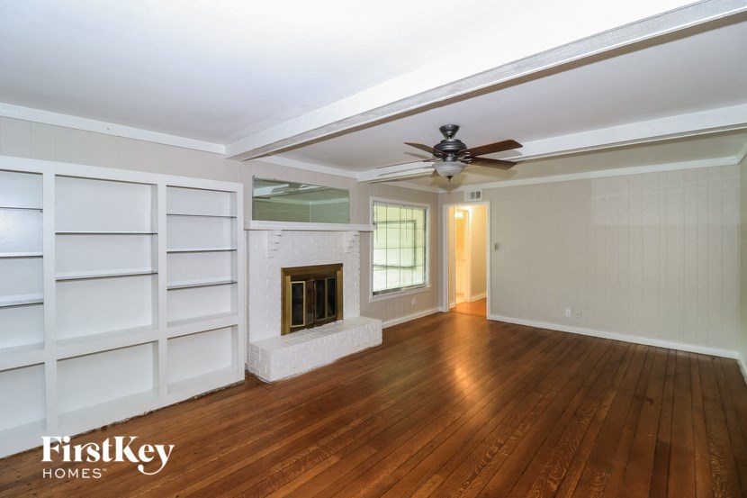 A spacious room with wood flooring and a fireplace.