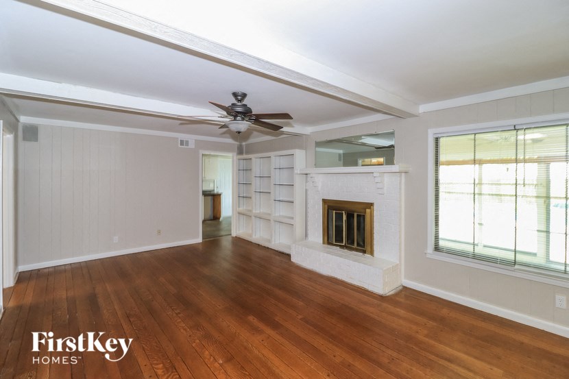A spacious room with wood flooring and a fireplace.