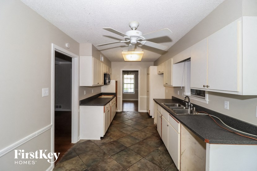 A kitchen with a tile floor and a ceiling fan.