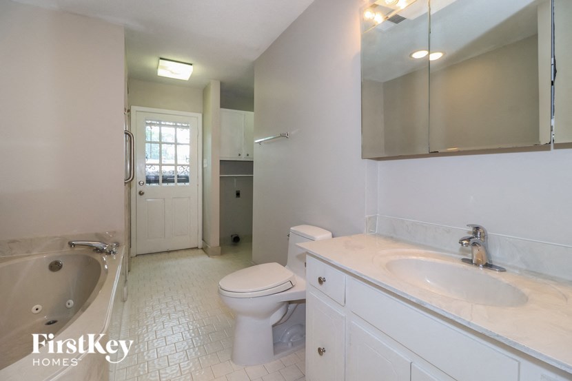 A white bathroom with a toilet, sink, and tub.