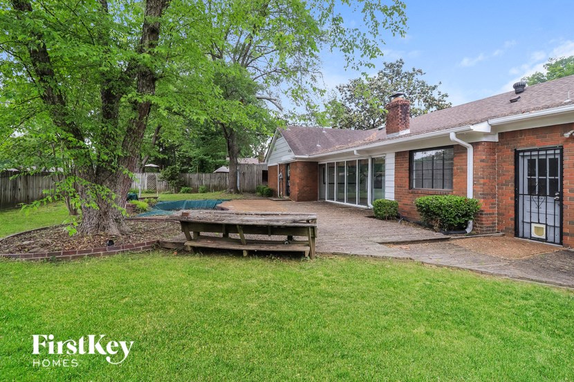 A brick house with a tree in front of it.