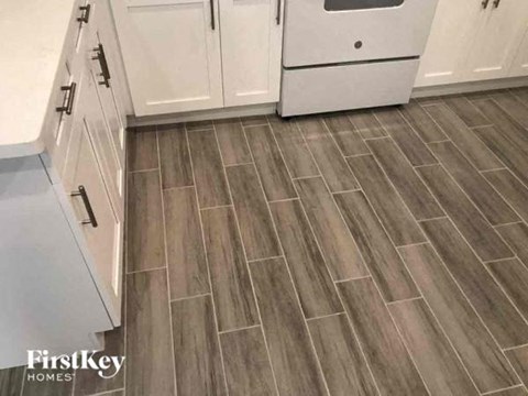 a kitchen with a wooden floor and white cabinets