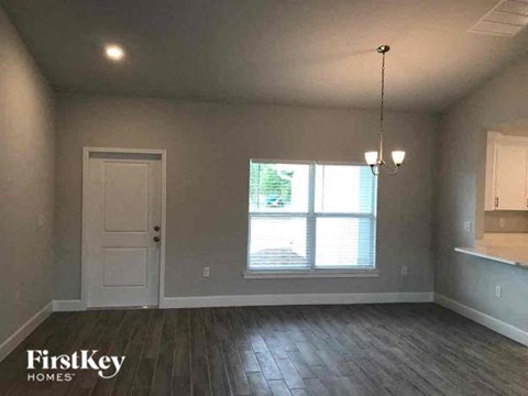 an empty living room with a white door and a window