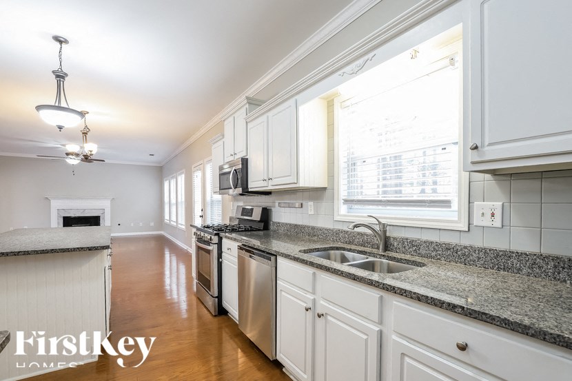 a large kitchen with granite counter tops and white cabinets