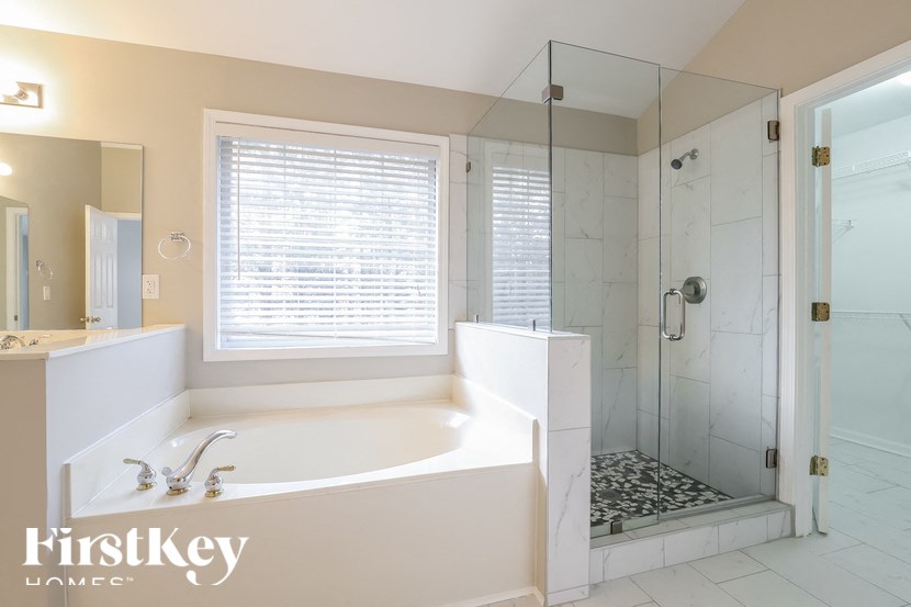 a white bathroom with a tub and a shower