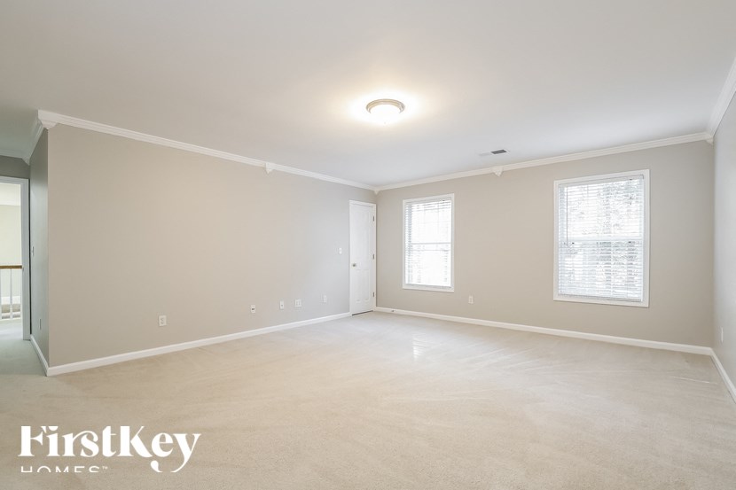 the spacious living room and dining room in a home with carpeted flooring