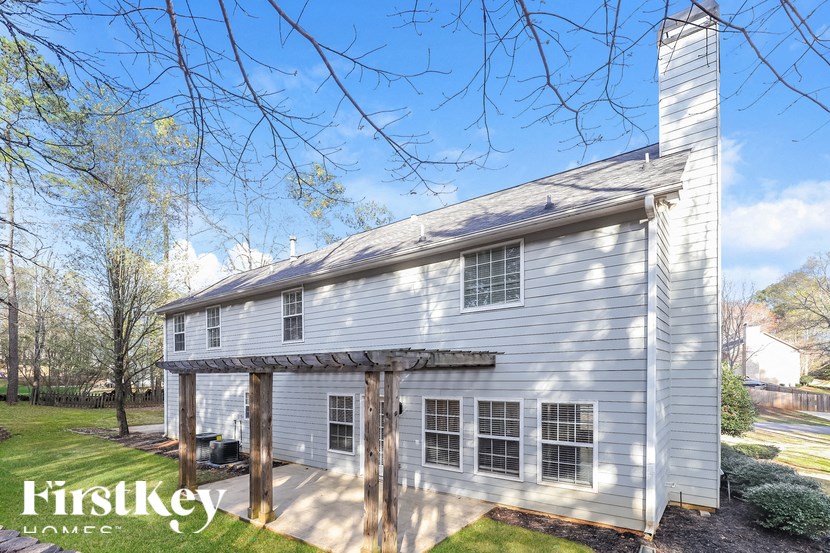 a white house with a covered porch and a tree