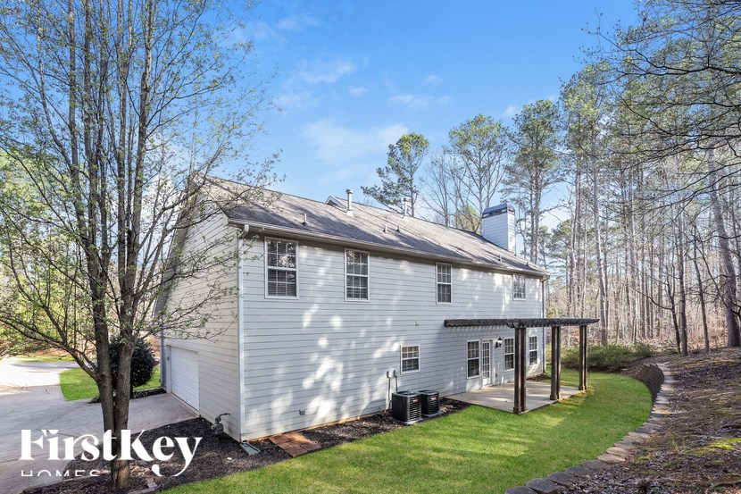 a small white house with a covered porch and trees