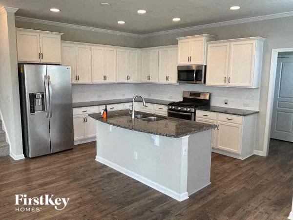 A kitchen with a granite countertop and stainless steel appliances.
