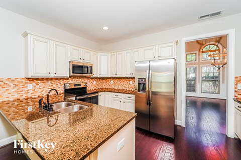 A kitchen with granite countertops and stainless steel appliances.