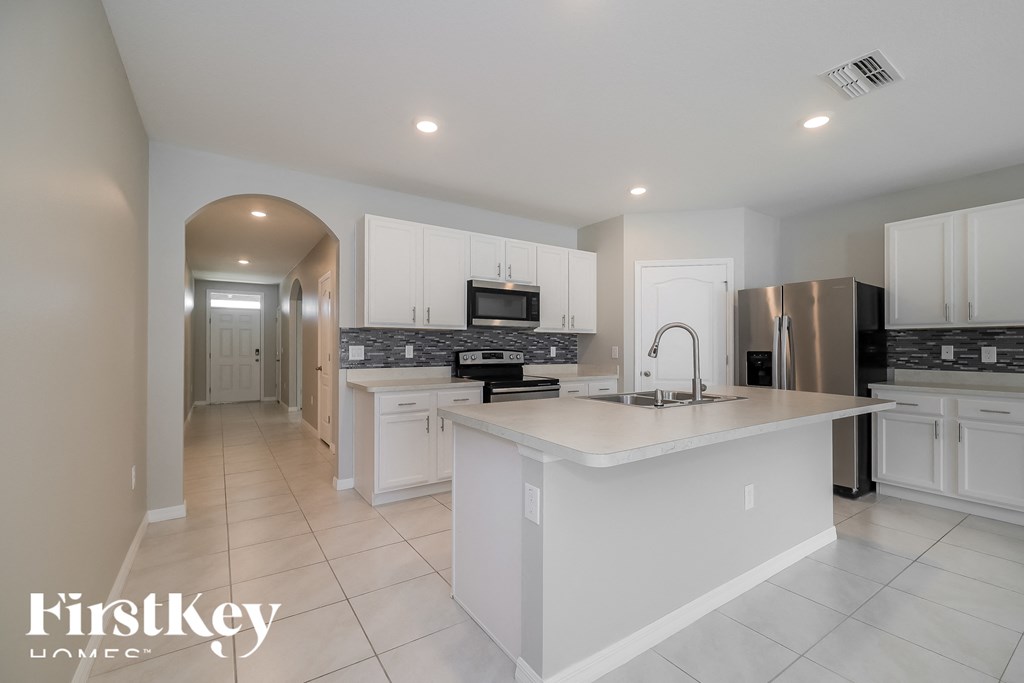 a large kitchen with white cabinets and a white counter top