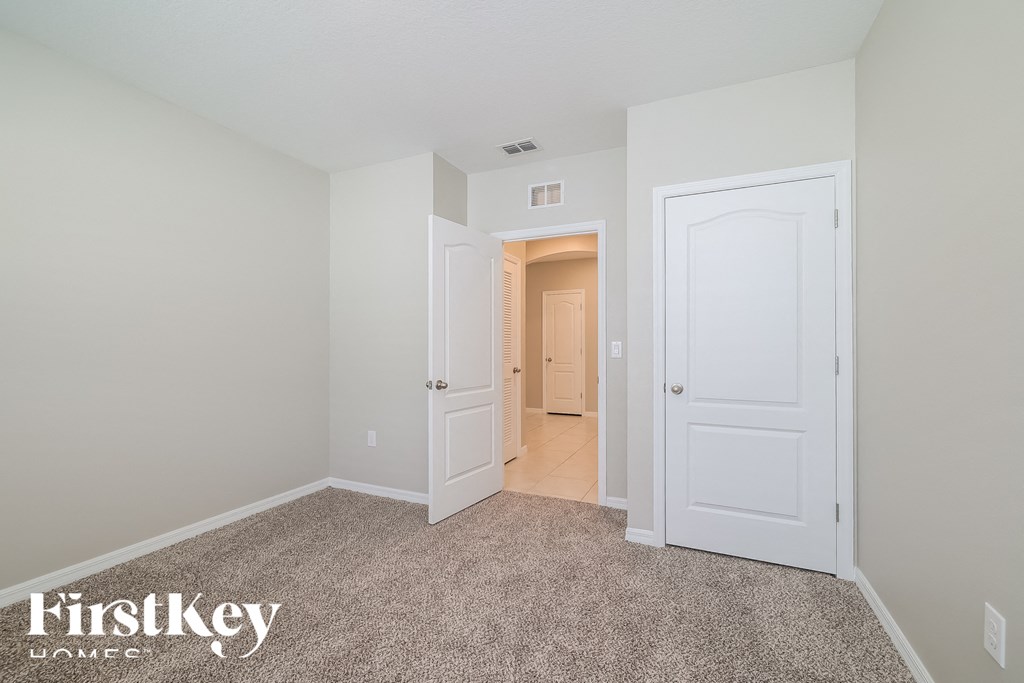 a bedroom with two closets and a door to a hallway