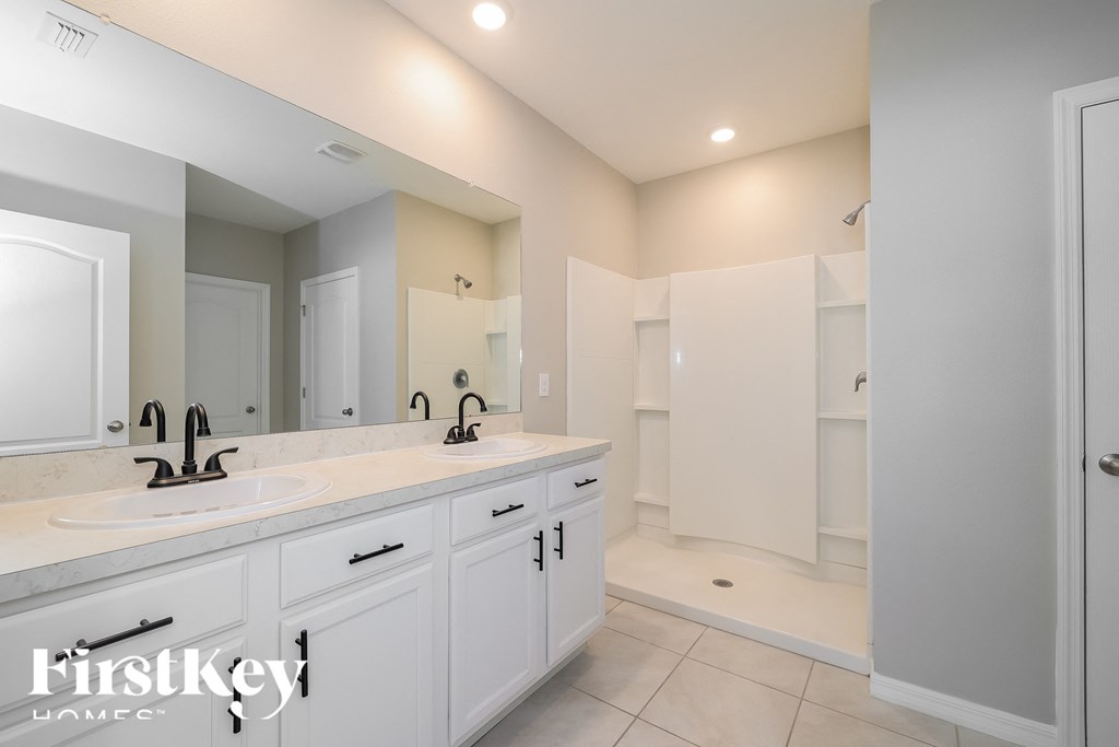 a white bathroom with two sinks and a large mirror