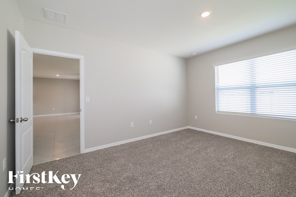 a bedroom with a carpeted floor and a large window