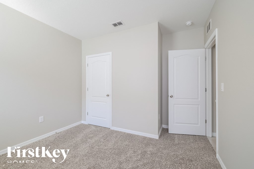 a bedroom with two doors and a carpeted floor