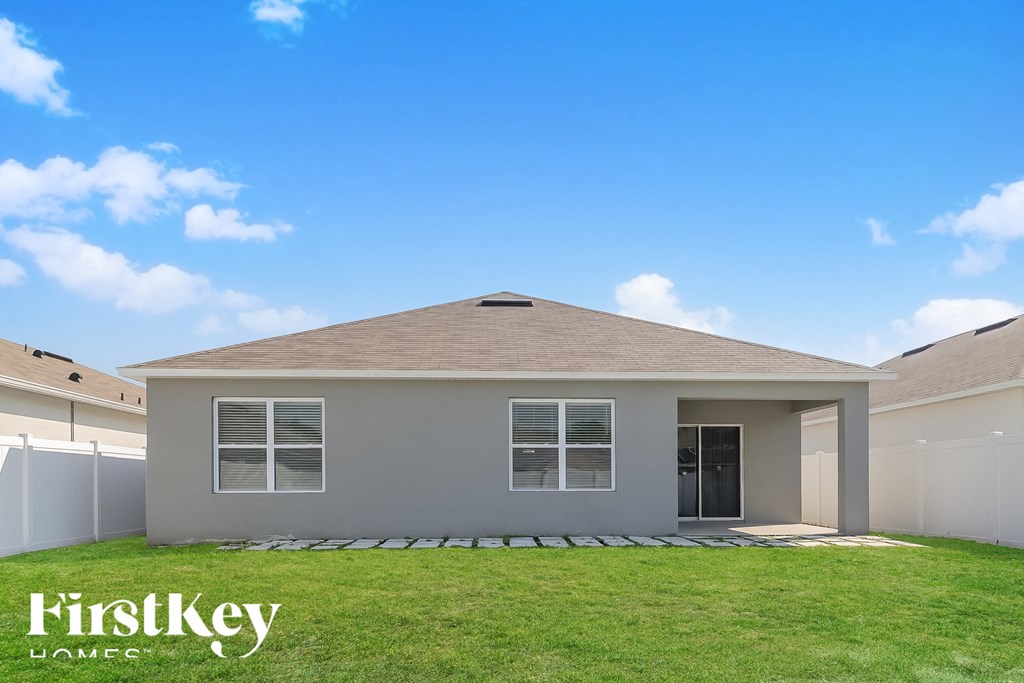 a white house with a lawn and a blue sky