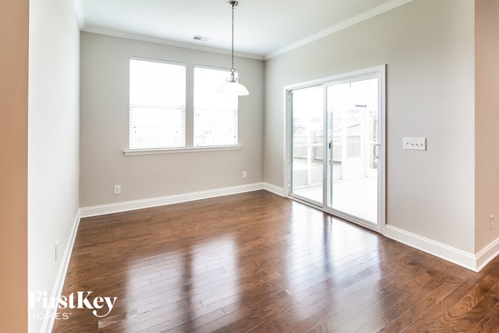 an empty living room with wood floors and a sliding glass door