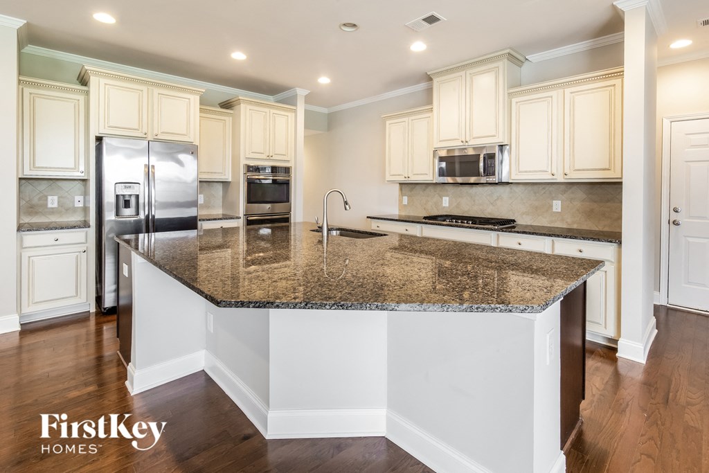 a kitchen with white cabinets and a granite counter top