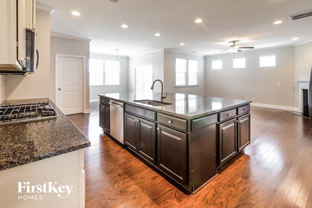 a kitchen with a large center island and hardwood floors