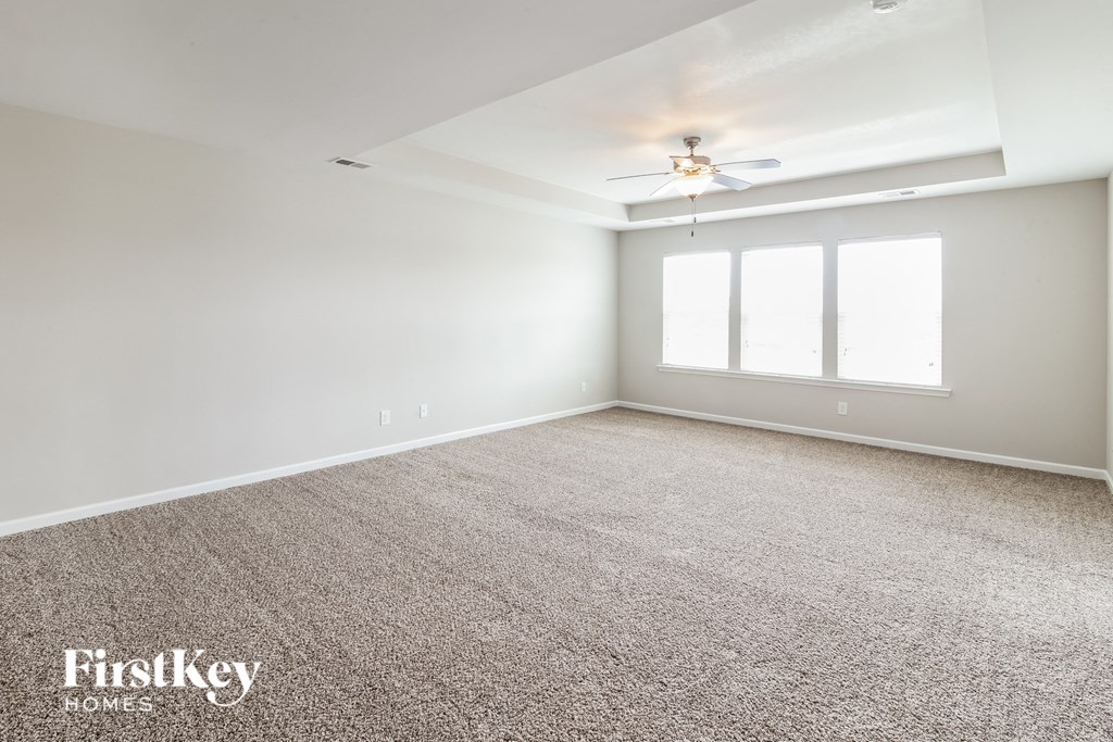 a room with carpet and a ceiling fan