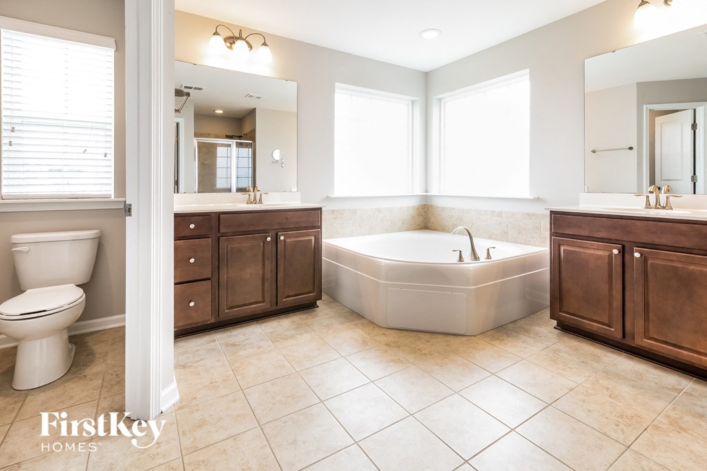 a bathroom with a tub and a sink and a toilet