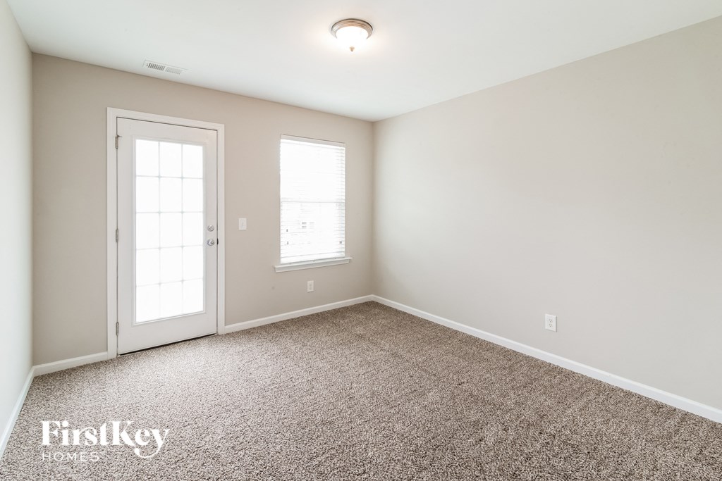 a room with carpet and a door and a window