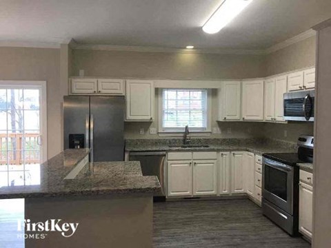 A kitchen with a granite countertop and stainless steel appliances.