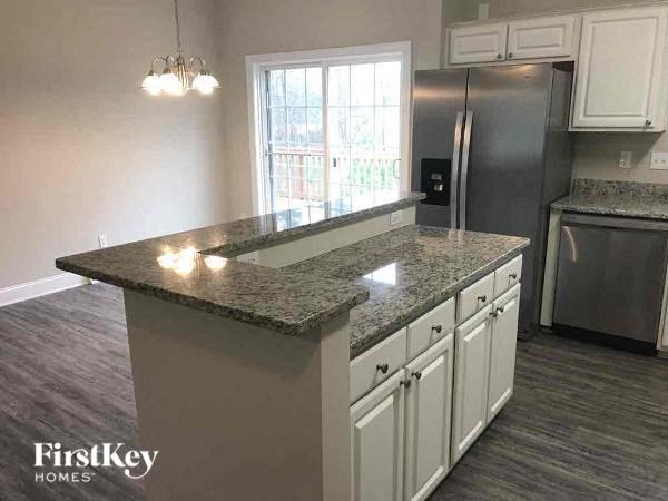 A kitchen with granite countertops and stainless steel appliances.