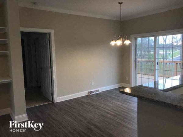 A room with a carpeted floor and a chandelier hanging from the ceiling.