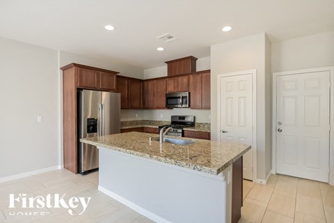 A kitchen with a granite countertop and a refrigerator.