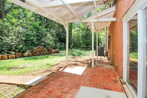 a patio with a brick floor and a white roof