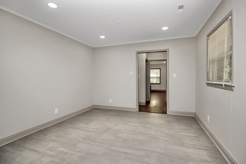 an empty living room with white walls and a large window