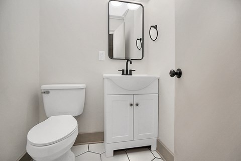 a bathroom with a toilet and a sink and a mirror