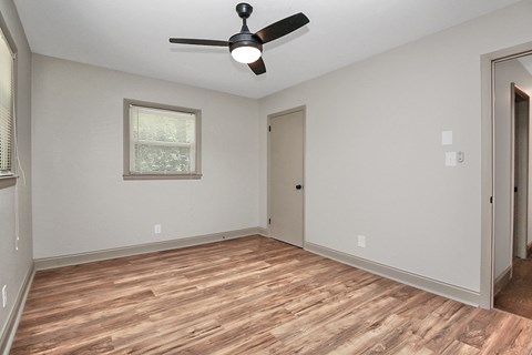 an empty living room with a ceiling fan