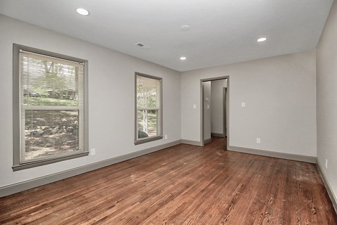 the living room of a new home with wood flooring and large windows