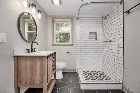 a white bathroom with a shower and a sink