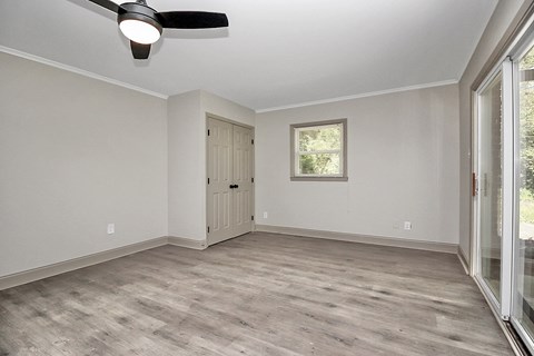 an empty living room with white walls and a sliding glass door