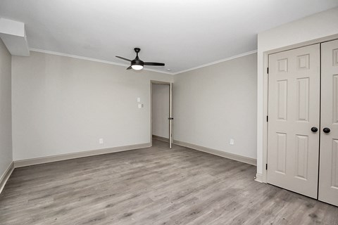 an empty living room with white walls and a ceiling fan