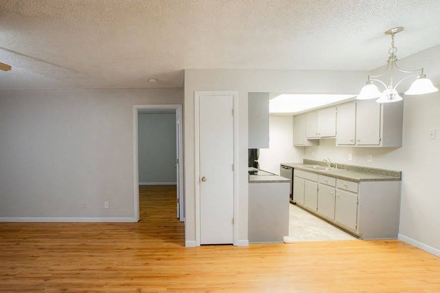 A kitchen area with a doorway leading to another room.
