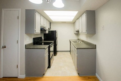 A kitchen with black appliances and white cabinets.