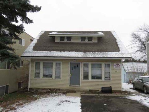 a yellow house with snow on the roof