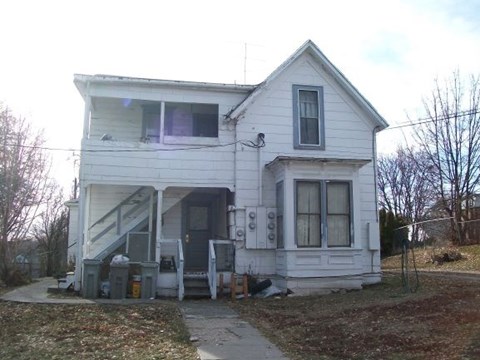 a white house with a porch and a sidewalk
