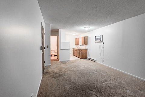 A room with a carpet floor and white walls.