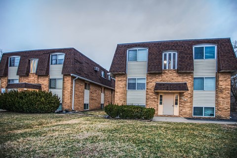 A row of houses with a grassy area in front.