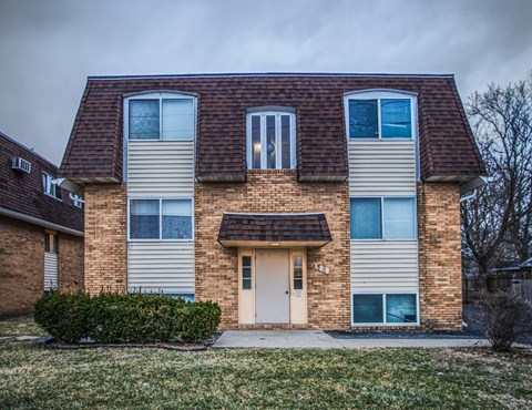 A two-story house with a brown roof and beige siding.