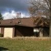 A house with a brown roof and a white garage door.