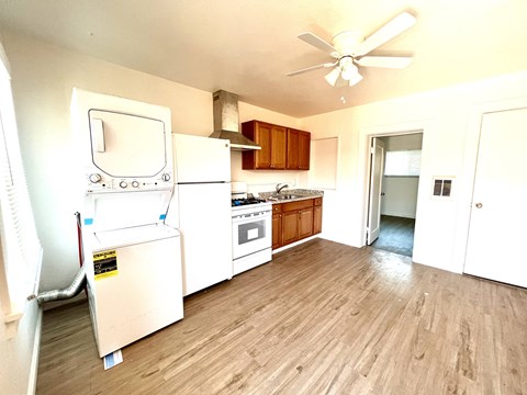 a kitchen with white appliances and a wooden floor