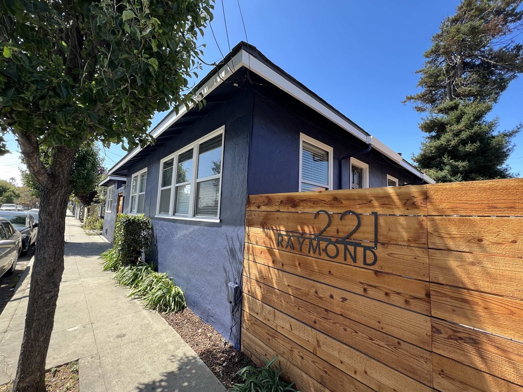 a wooden fence in front of a blue house