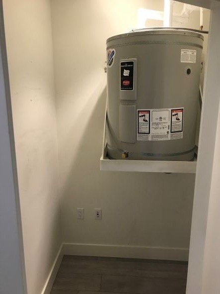 A water heater installed in a narrow hallway.